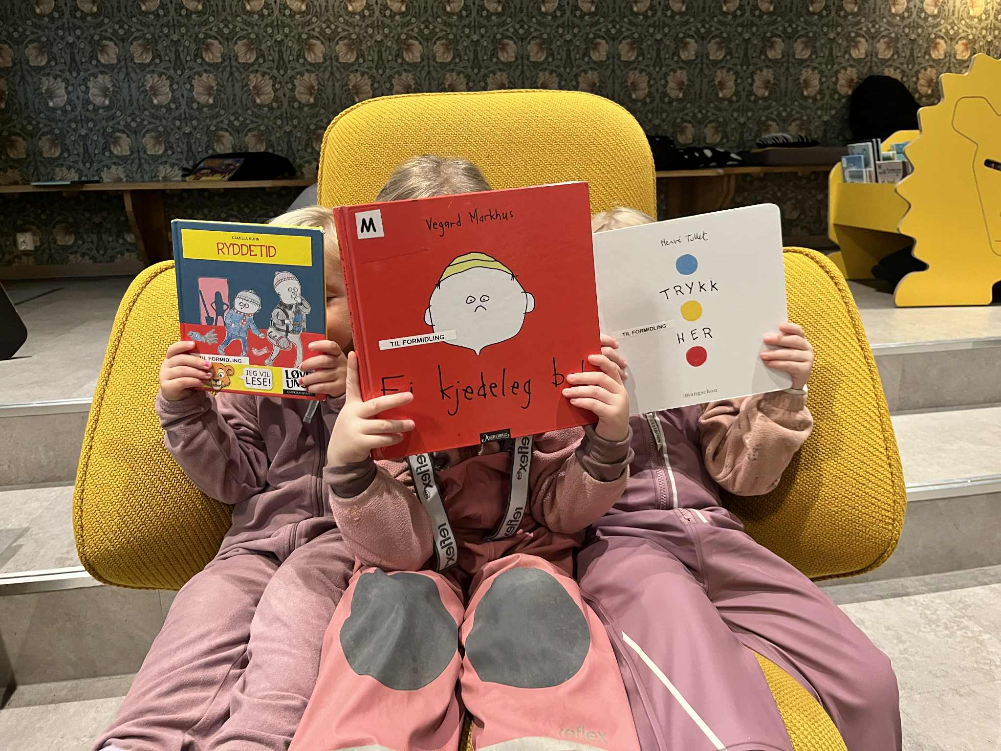 Tre barn leser Camilla Kuhns “Ryddetid” fra 2012, Vegard Markhus’ “Ei kjedeleg bok” fra 2017 og Hervé Tullets “Trykk her” fra 2014.