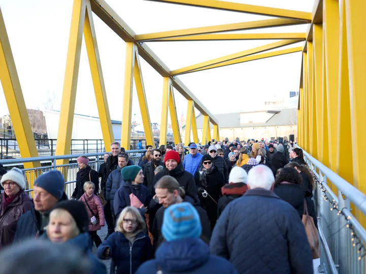 Folk som går over brua