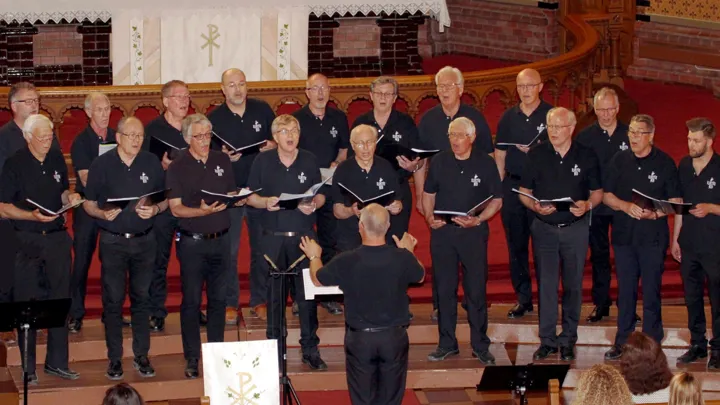 Et kor bestående av menn synger i en kirke