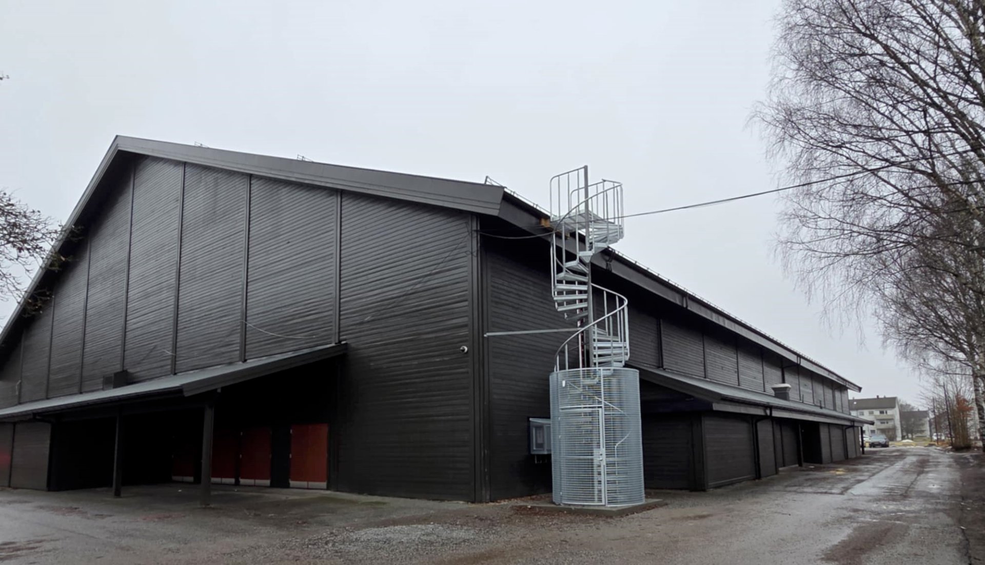 Utsiden av et stort bygg med sykkelvei ve siden av. 