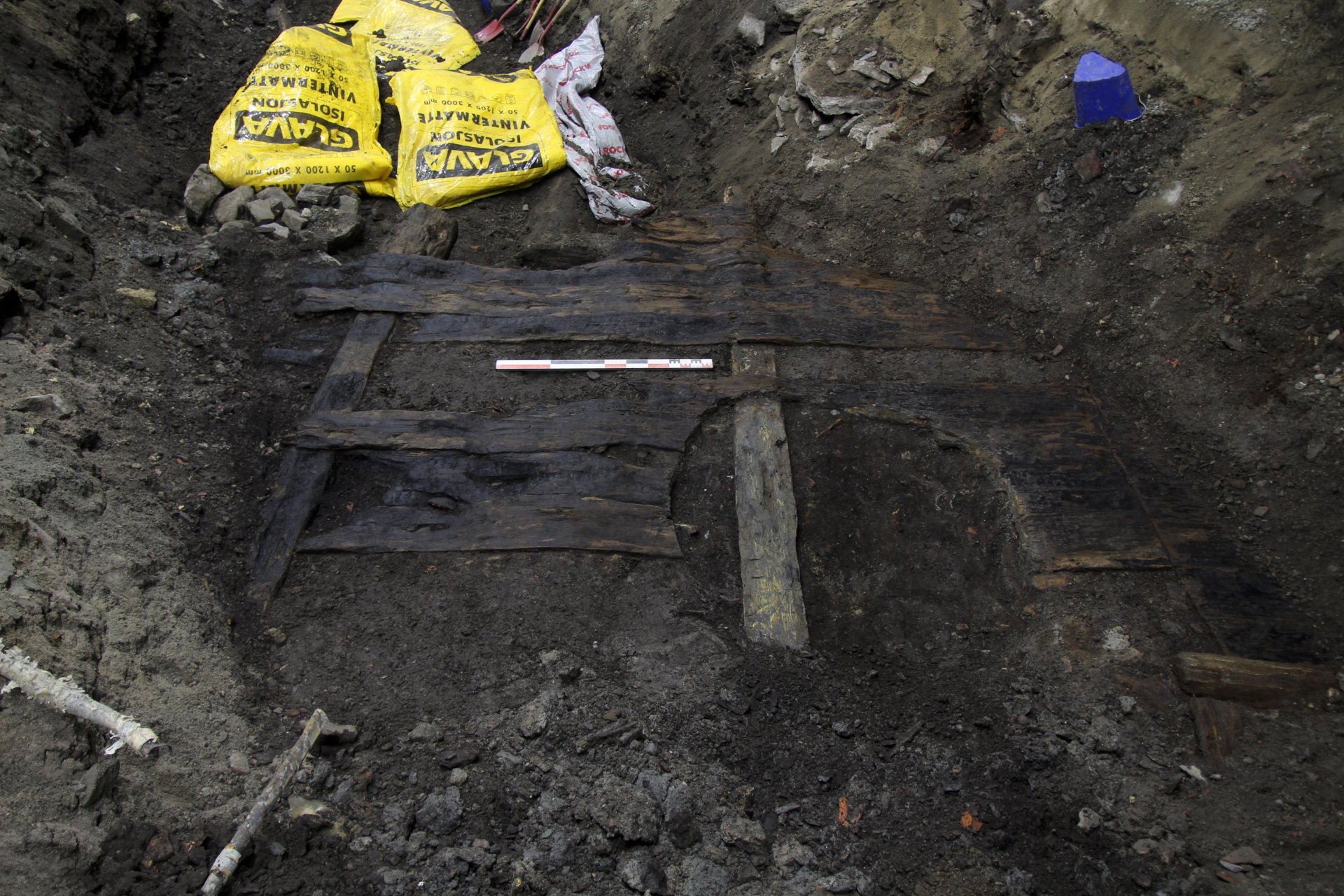 Utgravingsgrop med gamle planker fra en plankegate.