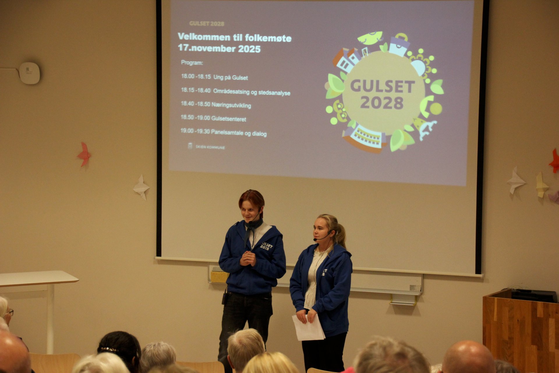 En gutt og en jente taler for publikum