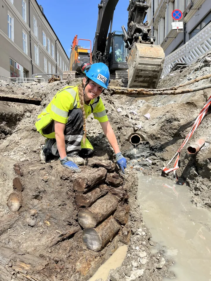 Tone Bergland sitter ned i grøfta hvor de fant brønnen.