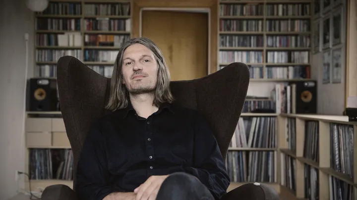 Tore Stavlund i en stol foran CD-samling.
