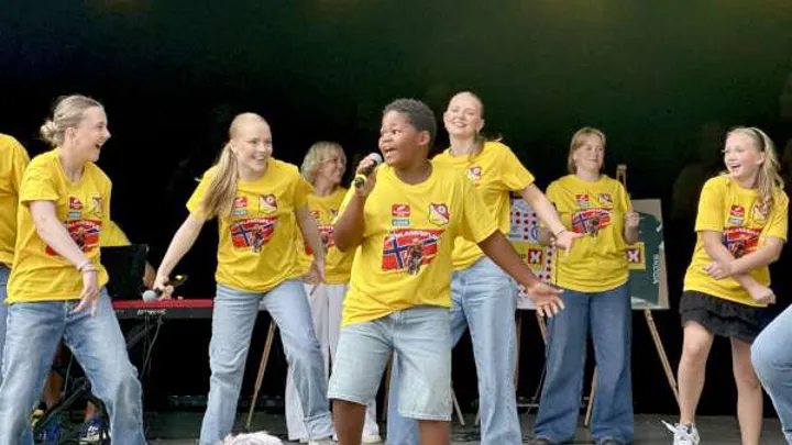 Barn som står på scenen i Brekkeparken og synger og danser.