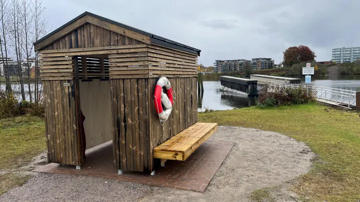 Lite trehus på et område ved vannet.