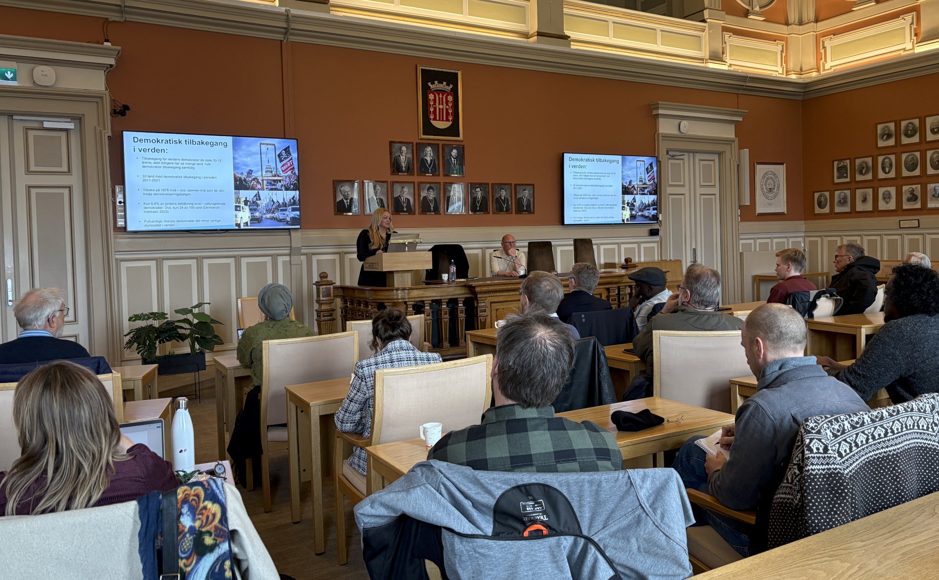 Person som hører på foredrag i bystyresalen i Skien