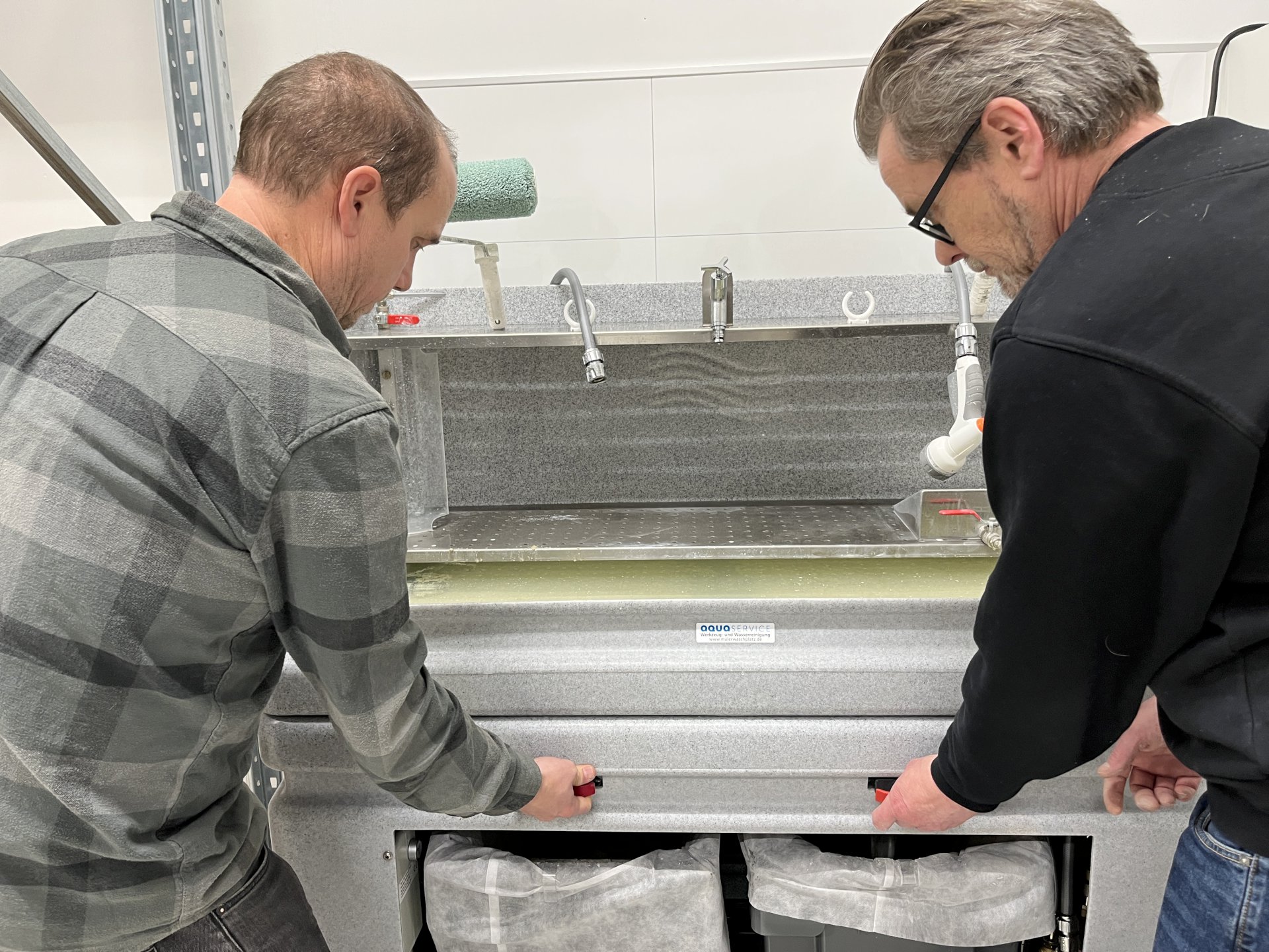 To menn som står ved en maskin.