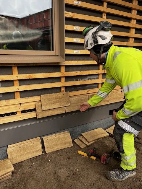 mann som monterer skjermtegl på vegg