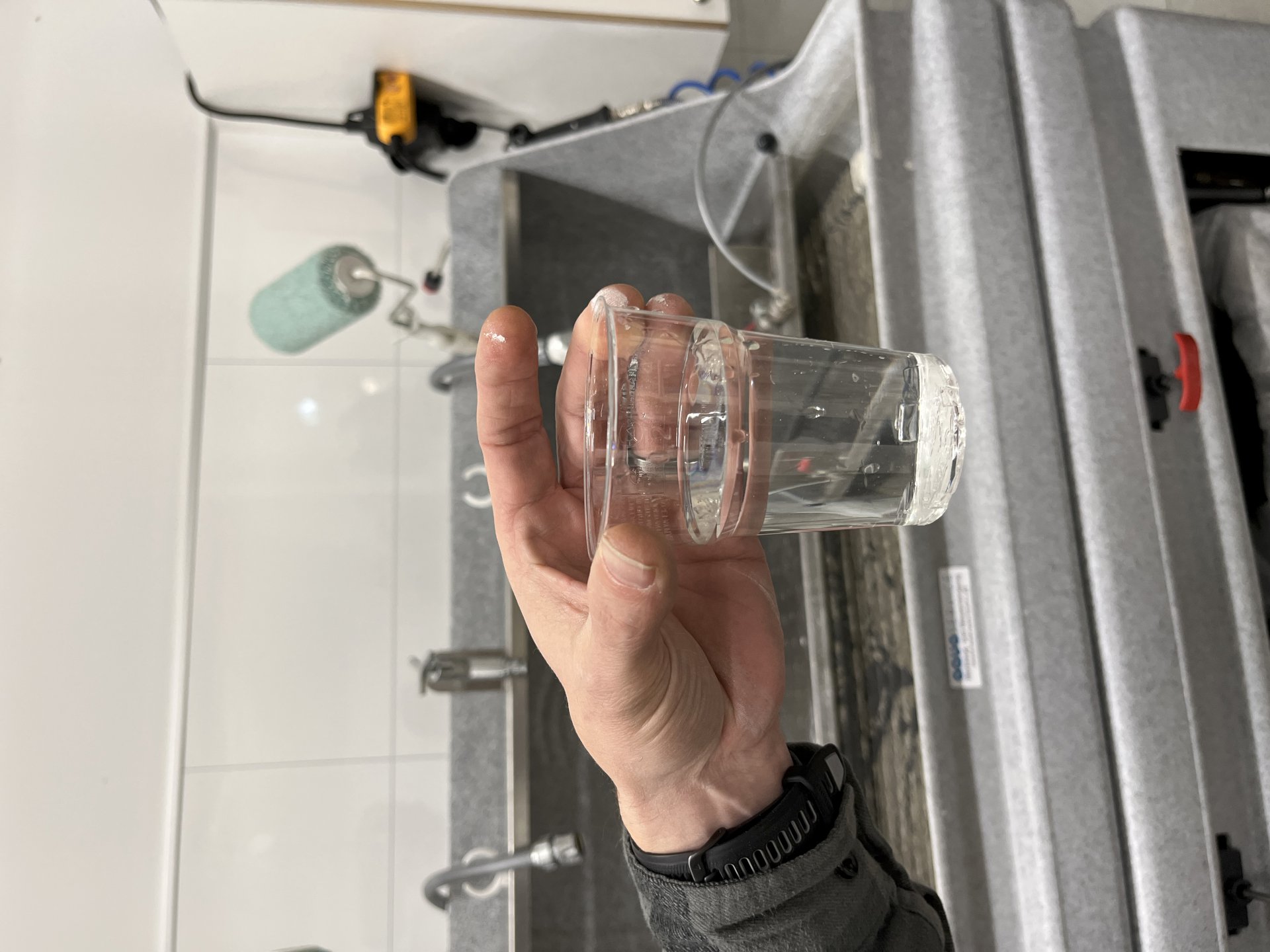 Hånd som holder et vannglass.