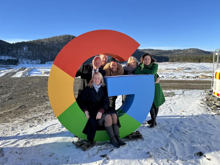 Seks personer sitter på en Google-logo