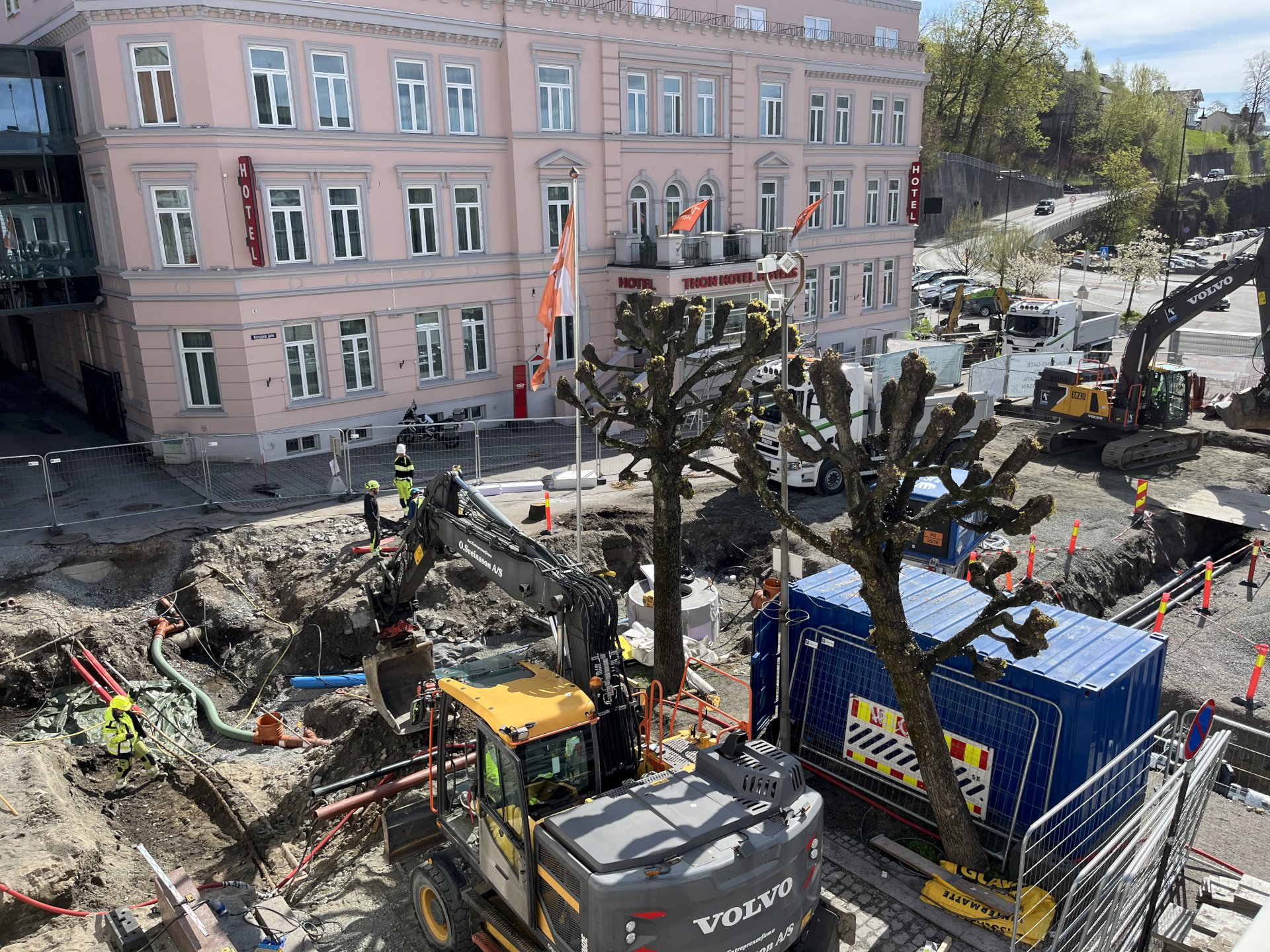 anleggsområde med gravemaskiner og containere.