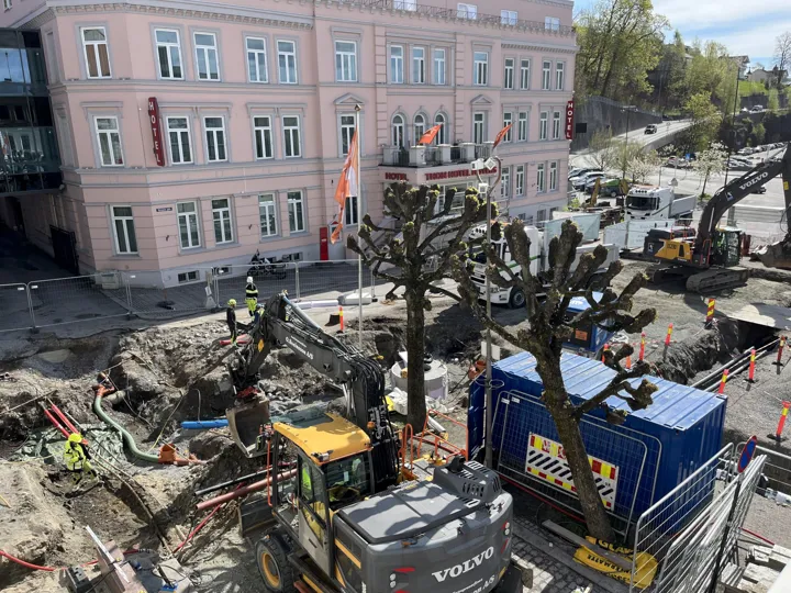 anleggsområde med gravemaskiner og containere.