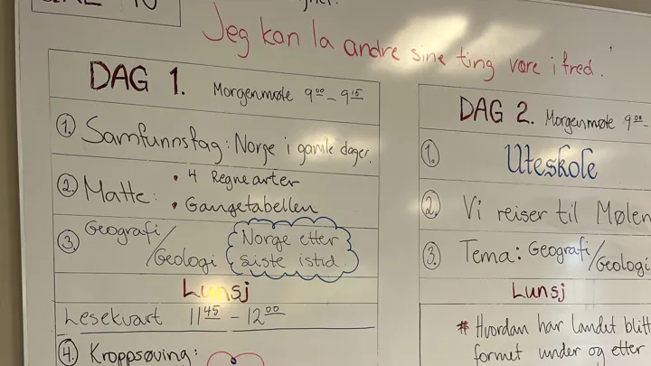 Tavle på vegg hvor det er skrevet tekst.