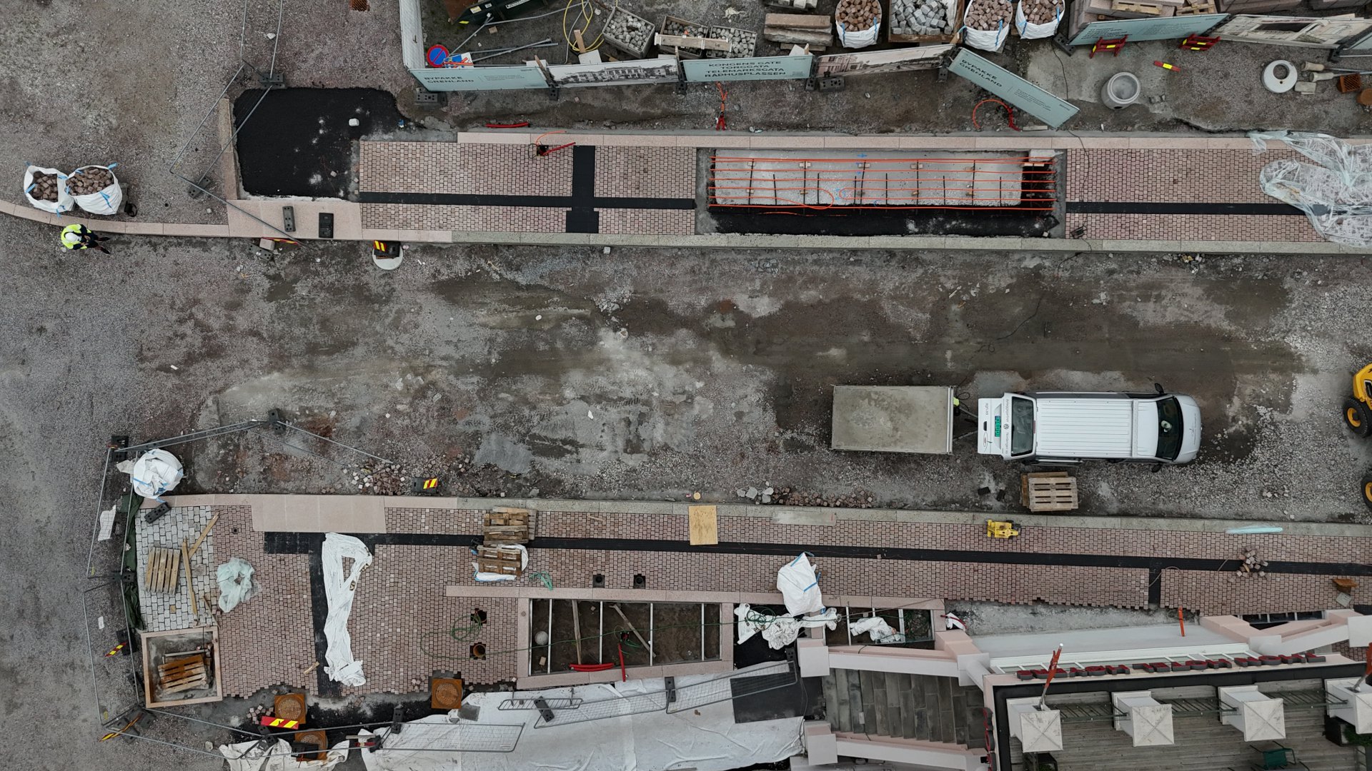 dronebilde som viser område med småstein som er lagt på fortauene ved rådhusplassen og hotellet. 