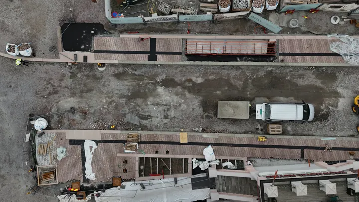 dronebilde som viser område med småstein som er lagt på fortauene ved rådhusplassen og hotellet.