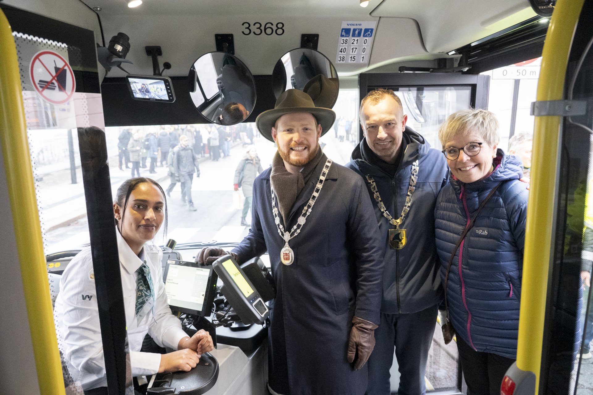 to menn og to kvinner inne i en buss.