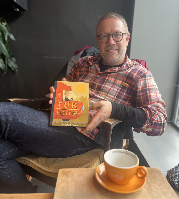 Per Ragnar Møkleby viser stolt fram boken sin. 