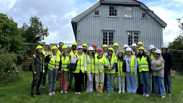 Deltakere, kursholdere og arrangører står utenfor Ibsens barndomshjem på Venstøp.